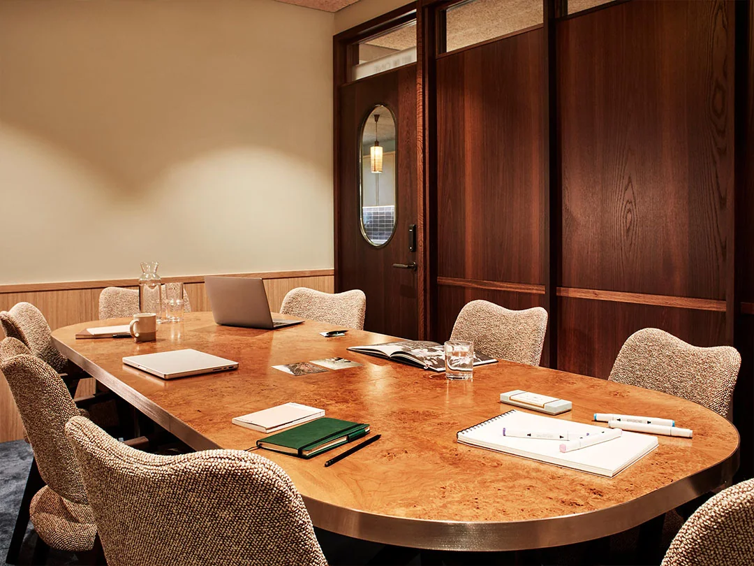 Private meeting room with a long wooden table, chairs and a wooden door