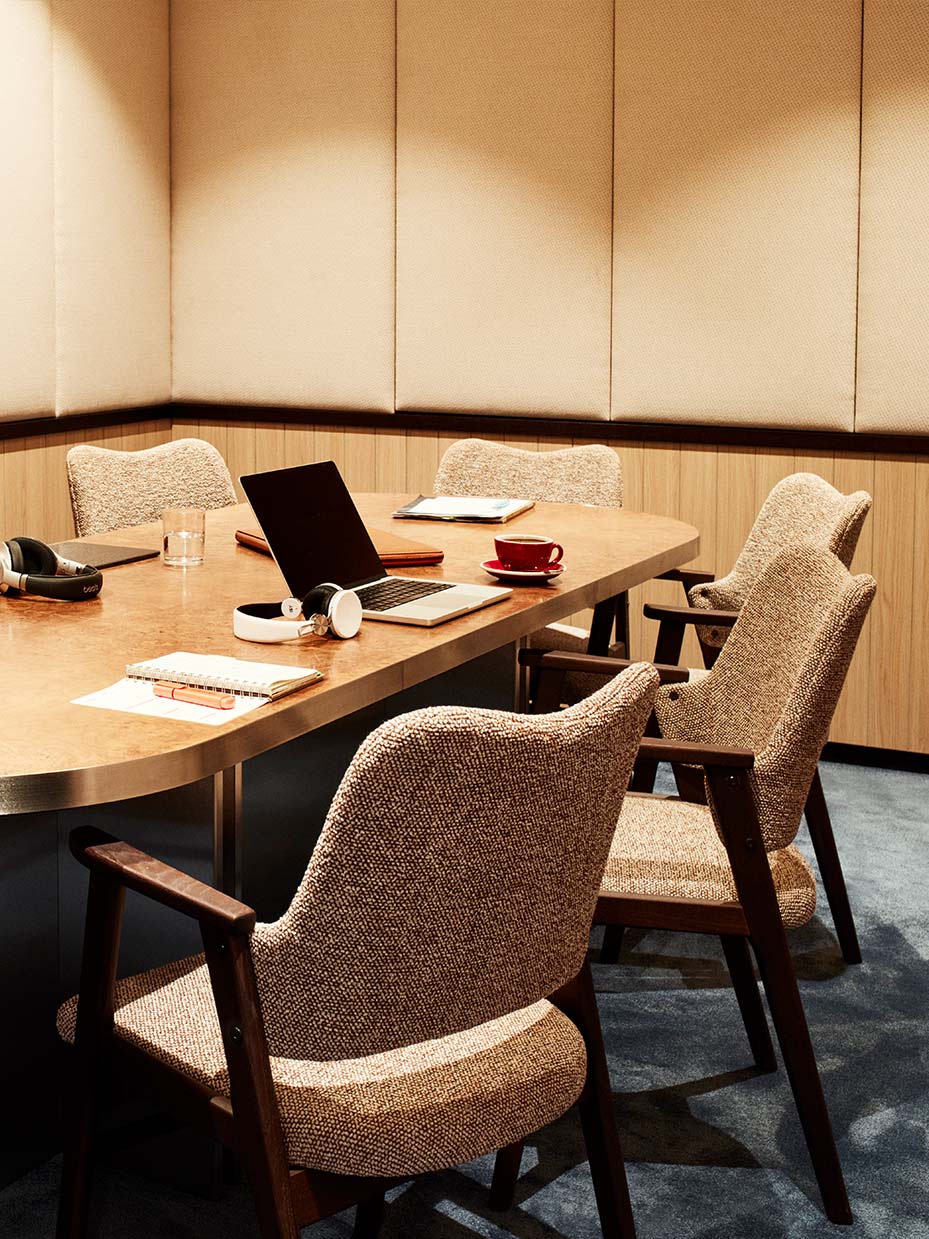The Live One podcast room with a wooden table, chairs and headphones